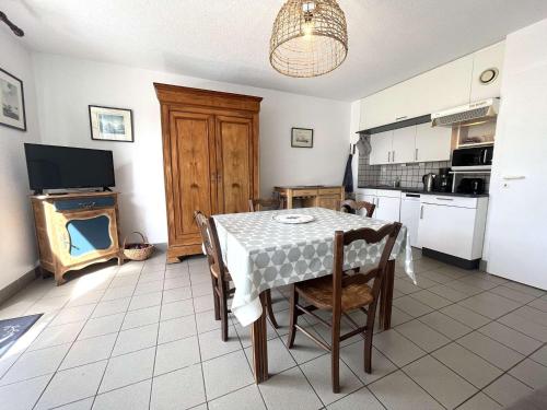 une cuisine et une salle à manger avec une table et des chaises dans l'établissement Appartement La Forêt-Fouesnant : port, plage et restaurants à pied, terrasse et parking - FR-1-481-146, à La Forêt-Fouesnant
