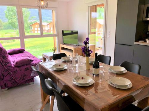 une salle à manger avec une table en bois et une cuisine dans l'établissement Superbe T3 au golf, parking privé, proche centre - FR-1-165A-178, à Barcelonnette