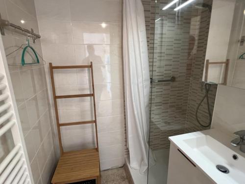 uma casa de banho com um chuveiro e uma prateleira de madeira. em Appartement Cabourg, 3 pièces, 4 personnes - FR-1-794-83 em Cabourg