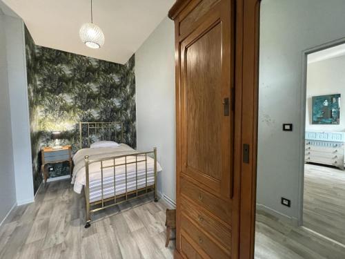 a bedroom with a bed and a wooden door at Demeure de caractère avec piscine et parking, animaux admis, wifi - FR-1-489-457 in Vernusse