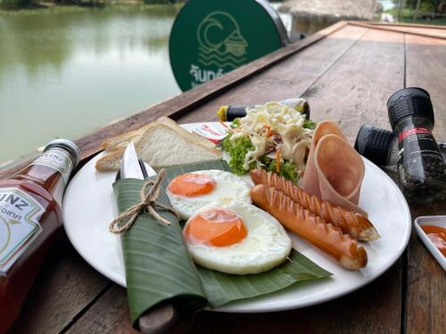 een bord met eieren en groenten op tafel bij Jantara Resort and Restaurant in Suratthani