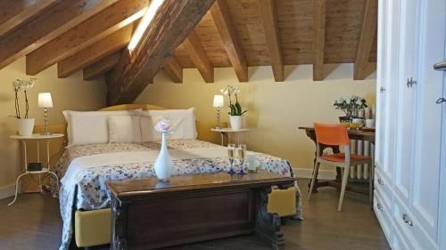 een slaapkamer met een bed en een tafel met een vaas erop bij Villa Monti in Varenna