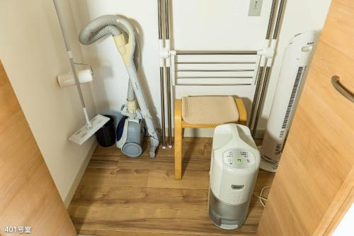 a room with a vacuum cleaner and a chair at NanEi Building in Kagoshima
