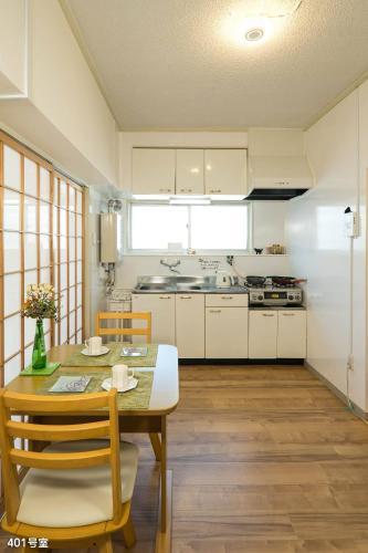 a kitchen with a table and chairs in a room at NanEi Building in Kagoshima