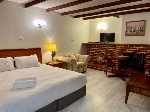 1 dormitorio con 1 cama grande y sala de estar en Sienna Lodge, en Yallingup