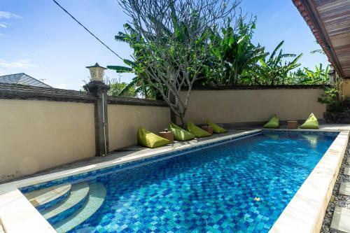 a swimming pool in the backyard of a house at Starloka Saba Bali Hotel in Blahbatu