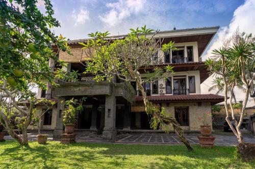 una vista exterior de una casa con árboles en Starloka Saba Bali Hotel, en Blahbatu