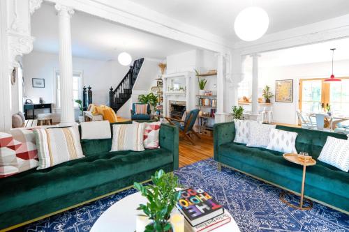a living room with green couches and a blue rug at 1850 Catskills Farmhouse on 8 acres in E. Durham in East Durham