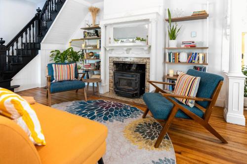 a living room with two chairs and a fireplace at 1850 Catskills Farmhouse on 8 acres in E. Durham in East Durham