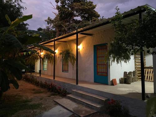 a small white building with a blue door and stairs at Cabaña Villa Mary-Aguachica in Aguachica