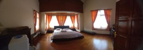 una camera con un letto e due finestre di Vila Dinar Tulip Hill a Lembang