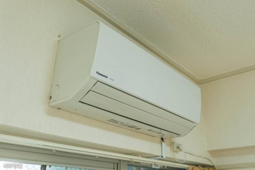 a microwave hanging from the ceiling in a kitchen at NanEi Building in Kagoshima