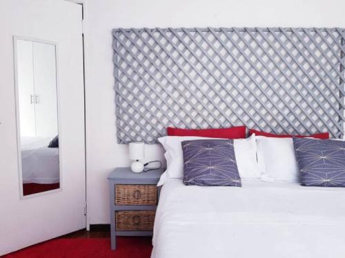 a bedroom with a white bed and a mirror at The Link on Bonsai in Kempton Park