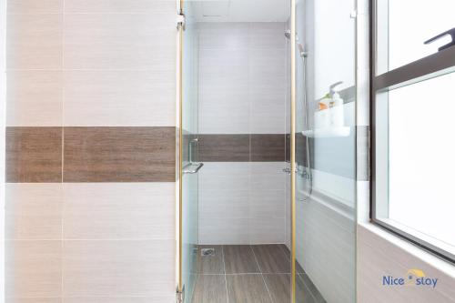a shower with a glass door in a bathroom at Căn hộ Orchard Garden - SG Airport Homestay in Ho Chi Minh City