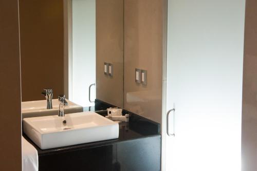 uma casa de banho com um lavatório branco e um espelho. em MBM Red Sun Hotel em Monterrey
