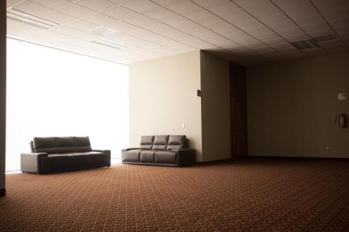 two black leather chairs in an empty room at MBM Red Sun Hotel in Monterrey