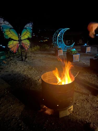 a pot over a fire with butterflies in the background at Glamping Cielo Roto in Sutamarchán