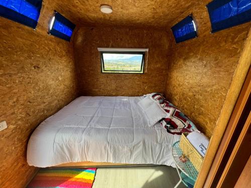 uma cama num pequeno quarto com uma janela em Glamping Cielo Roto em Sutamarchán