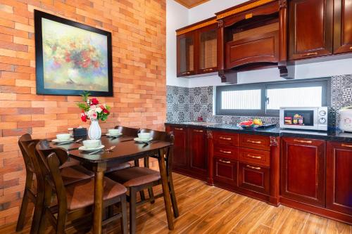 a kitchen with a table with chairs and a vase of flowers at IRIS HILL VILLA in Thôn Dương Xuân Hạ