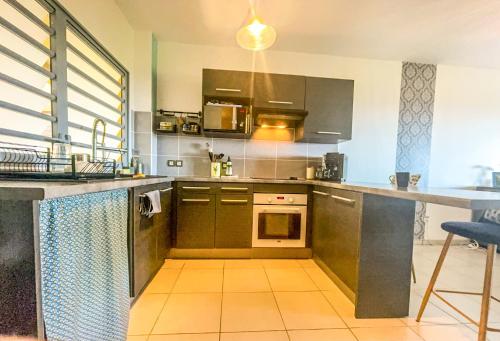 a kitchen with a sink and a stove top oven at Le Cocon Appartement Vue Mer et Montagne in Sainte-Marie