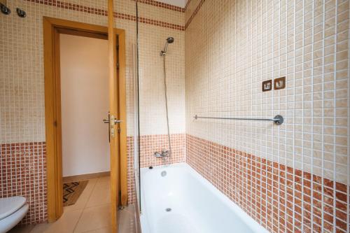 een badkamer met een bad en een toilet bij Amazing Penthouse Giralda Views 8 pax, Parking Optional in Sevilla