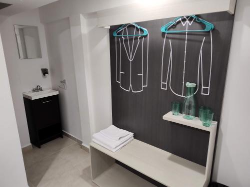 een badkamer met een zwart-witte muur met hangers bij San Marcos Hotel Guaymas in Guaymas