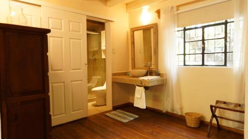 a bathroom with a sink and a toilet and a window at Meztli: Casa Boutique & Spa in Mexico City