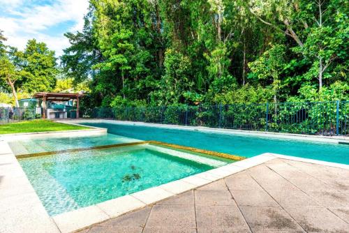 a swimming pool with blue water in a yard at Blue Lagoon Villas in Trinity Beach