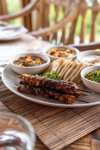 a plate of food on a table with bowls of food at Malabar Hill in Weligama