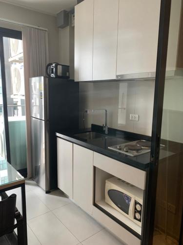 a kitchen with a stove and a refrigerator at Base Condos in Pattaya South