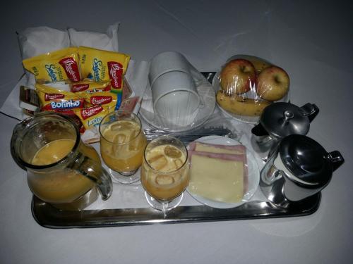 a tray with drinks and food on a table at Medieval Motel e Hospedagem in Ribeirão Preto