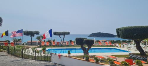 a resort with a swimming pool and flags at Hotel Cristina in Diamante