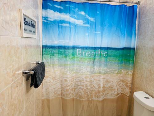 einen Duschvorhang mit den Worten, atme den Strand tief ein in der Unterkunft 2BD 2BTH Condo in San Juan Unit 1 in San Juan