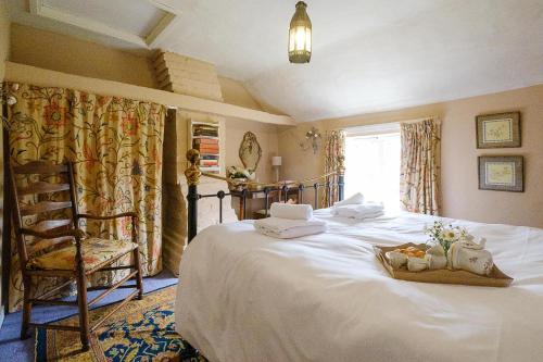 a bedroom with a large white bed with a chair at 5 Mariners View in Friston