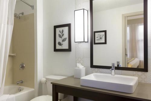 y baño con lavabo, aseo y espejo. en Country Inn & Suites by Radisson, Bloomington at Mall of America, MN en Bloomington
