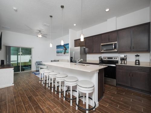 a kitchen with a large island with bar stools at Breezy Villa in Palm Coast