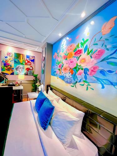 a bedroom with a bed with a painting on the wall at Yuu Hotel Ubon Ratchathani in Ubon Ratchathani