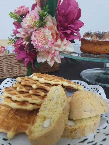 a plate of waffles and bread on a table with flowers at La casa dei nonni in San Salvo
