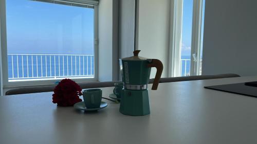 a coffee maker and two cups on a table at Relais Solis in Ponza
