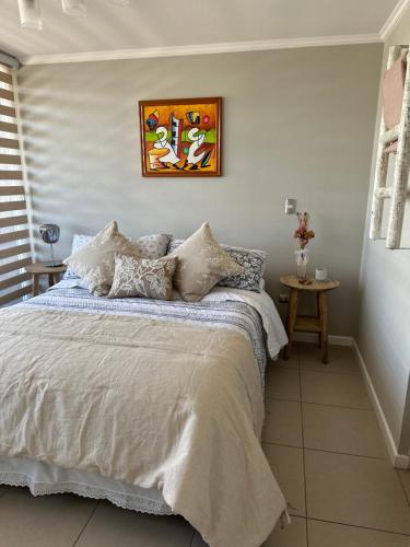 1 dormitorio con 1 cama y una pintura en la pared en Descanso y Relajo Deluxe en La Serena, en La Serena