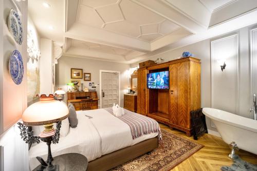 a bedroom with a bed and a tub and a television at Yuu Hotel Ubon Ratchathani in Ubon Ratchathani