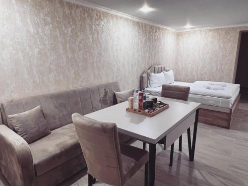 a living room with a couch and a table and a bed at Gardenia in Tsqaltubo