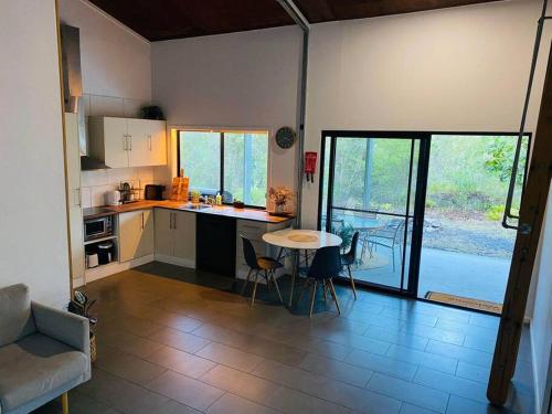 uma cozinha e sala de estar com mesa e cadeiras em Austinville Hinterland Chalet em Neranwood