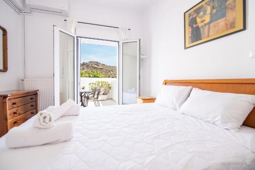 - une chambre avec un grand lit blanc et un balcon dans l'établissement Izabella's House Naxos, à Mélanes