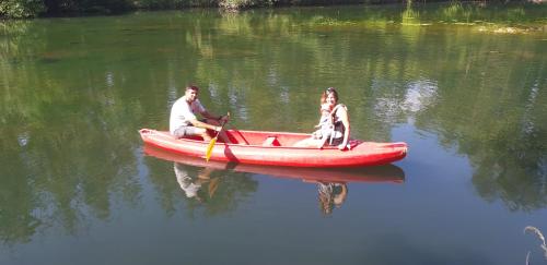 a man and a woman in a red boat on the water at Logis des Magnans -Les terrasses du Coutach - in Sauve