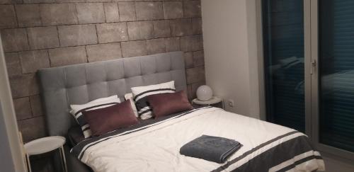 a bedroom with a large bed with a brick wall at Aksioma Kotor in Kotor