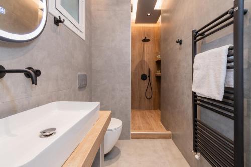 a bathroom with a white sink and a toilet at Nuovo Suite in Neos Marmaras