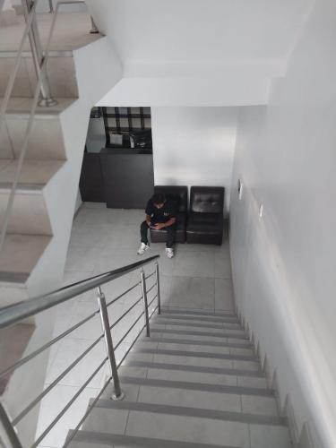 a person sitting in the middle of a stairs at Hospedaje Moralillos in Yurimaguas