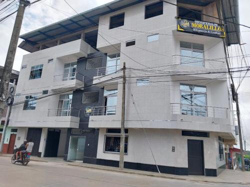 a white building with a sign on the side of it at Hospedaje Moralillos in Yurimaguas