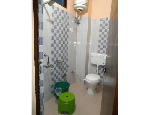a small bathroom with a toilet and a shower at Pine Wood Resort, Barkot in Barkot
